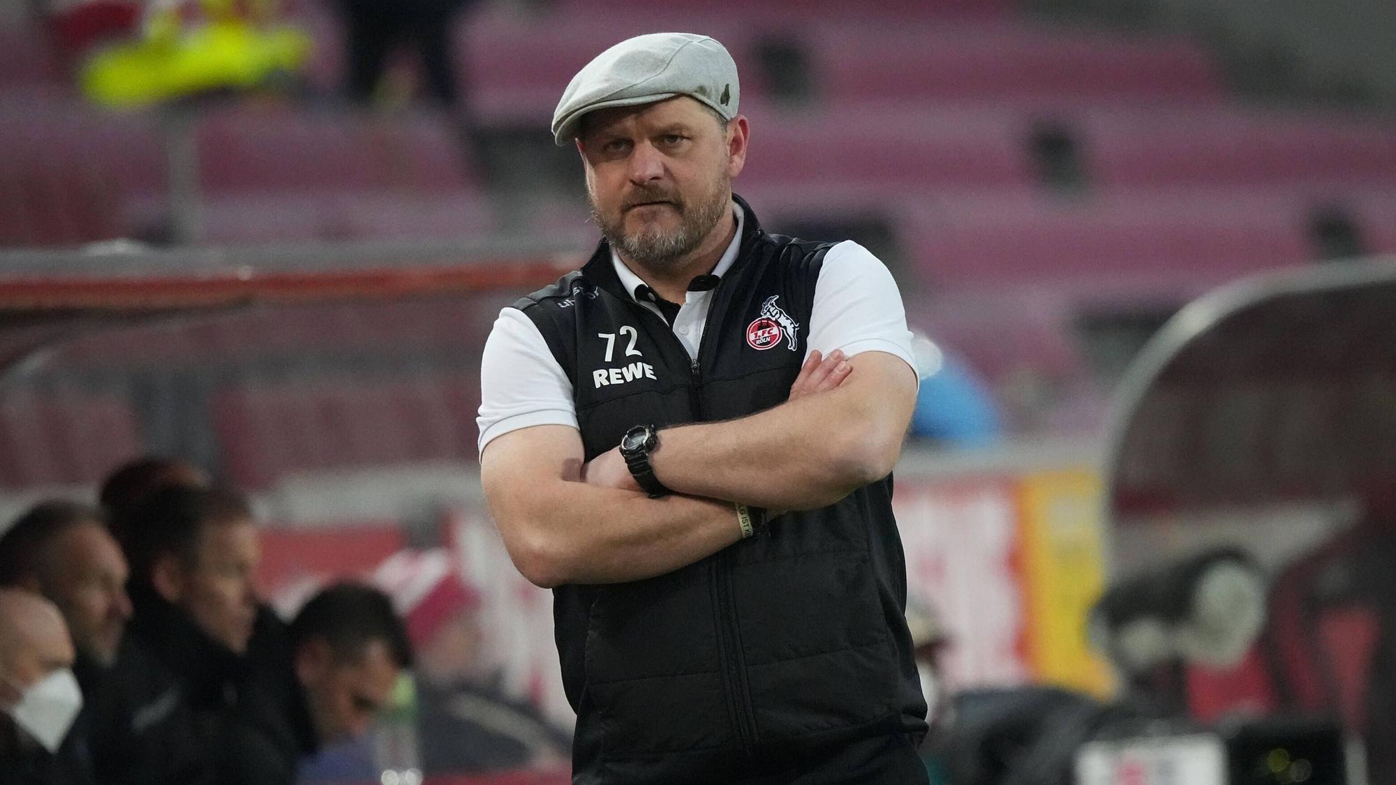 Steffen Baumgart beobachtet mit verschränkten Armen das Spiel seines 1. FC Köln gegen den FC Bayern München.
