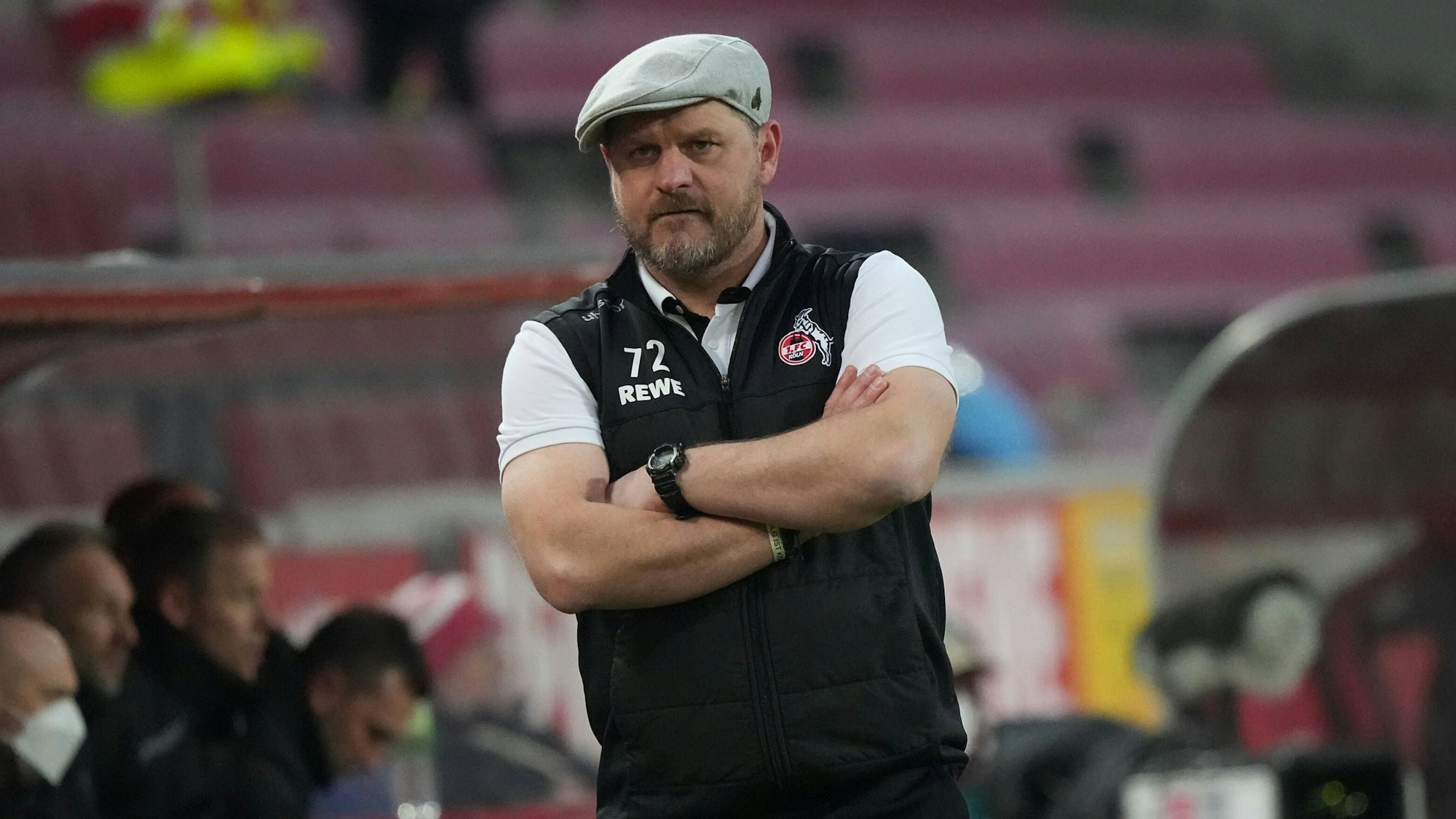 Steffen Baumgart beobachtet mit verschränkten Armen das Spiel seines 1. FC Köln gegen den FC Bayern München.