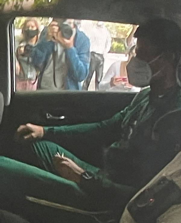 Novak Djokovic (l) sitzt auf dem Rücksitz eines Autos, als er an einem Abschiebehotel ankommt.