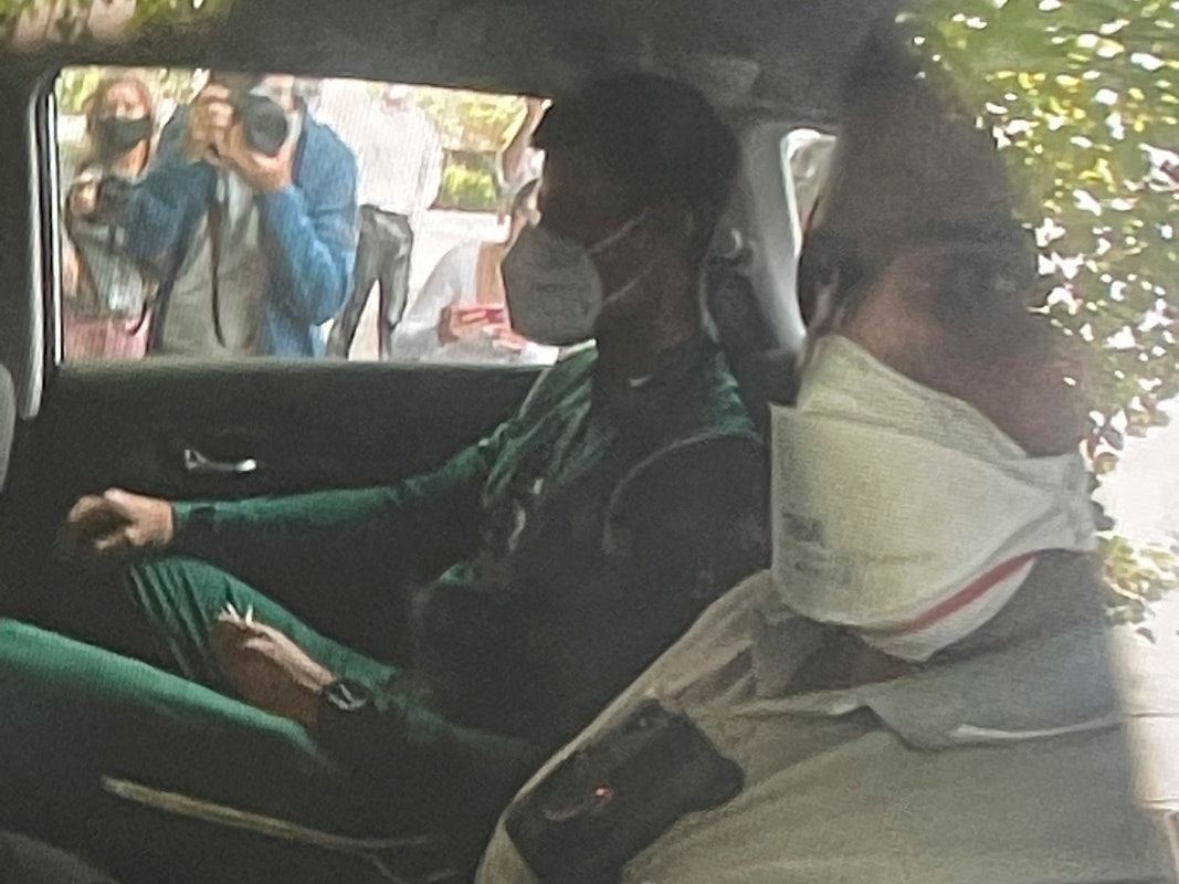 Novak Djokovic (l) sitzt auf dem Rücksitz eines Autos, als er an einem Abschiebehotel ankommt.