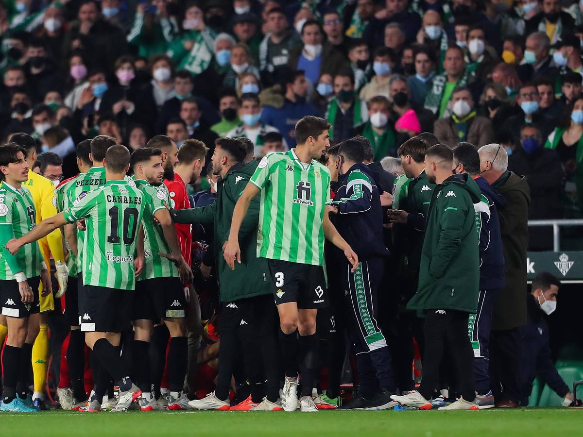 Spieler von Real Betis und dem FC Sevilla diskutieren am Spielfeldrand.