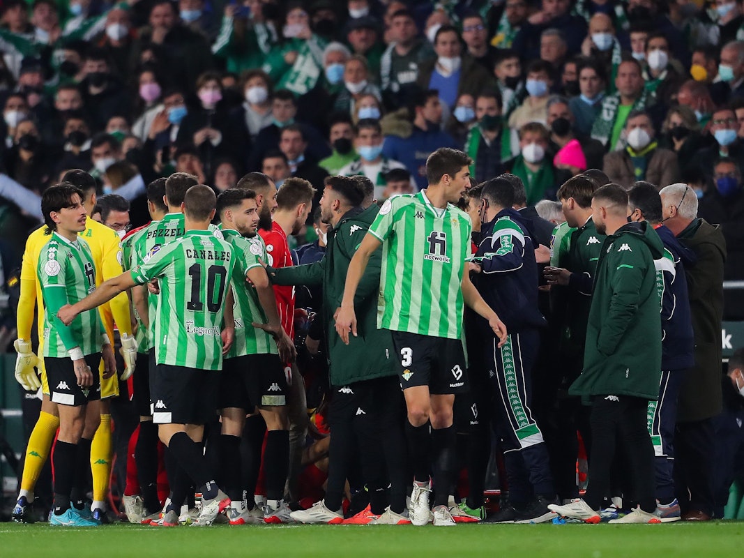 Spieler von Real Betis und dem FC Sevilla diskutieren am Spielfeldrand.