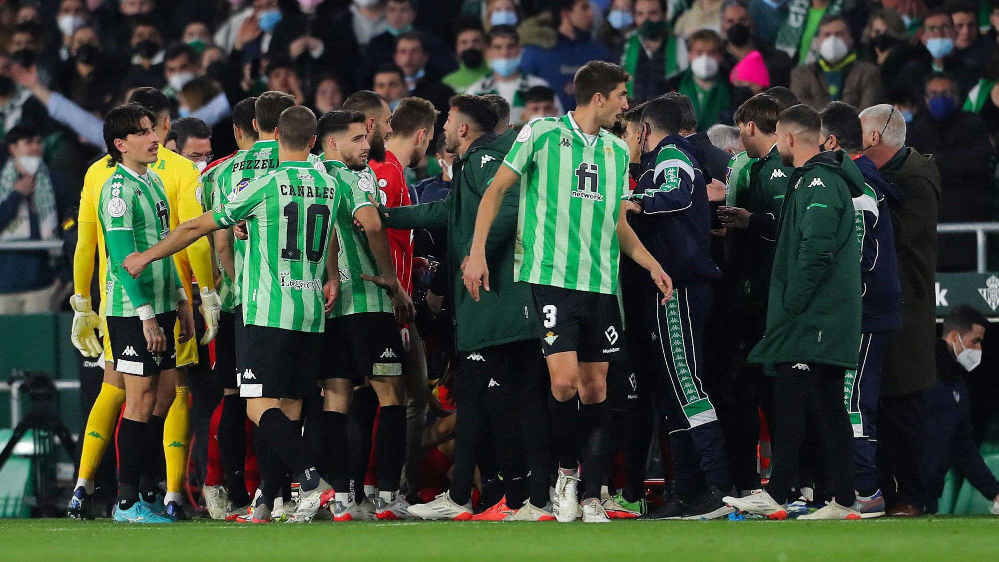 Spieler von Real Betis und dem FC Sevilla diskutieren am Spielfeldrand.