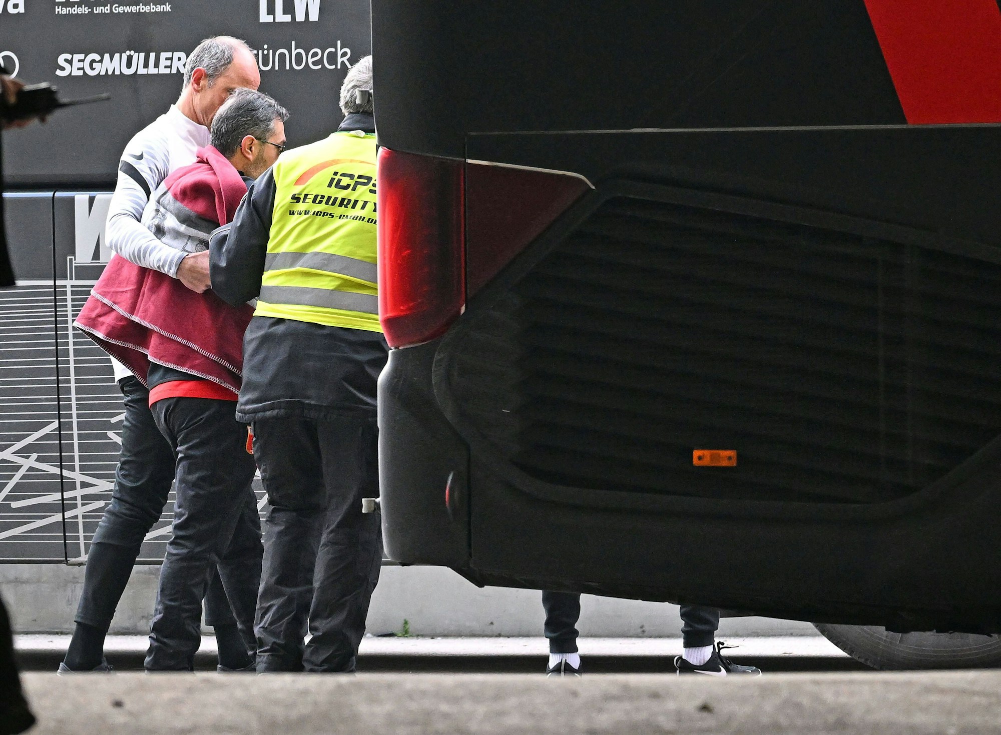Der Busfahrer der Augsburger wird vom Rettungsdienst behandelt.