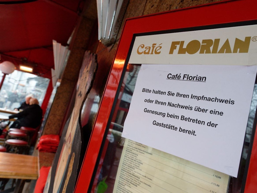 12.01.2022, Nordrhein-Westfalen, Düsseldorf: Ein Schild am Eingang zum Café Florian fordert die Gäste zum bereithalten des Impfnachweises auf.