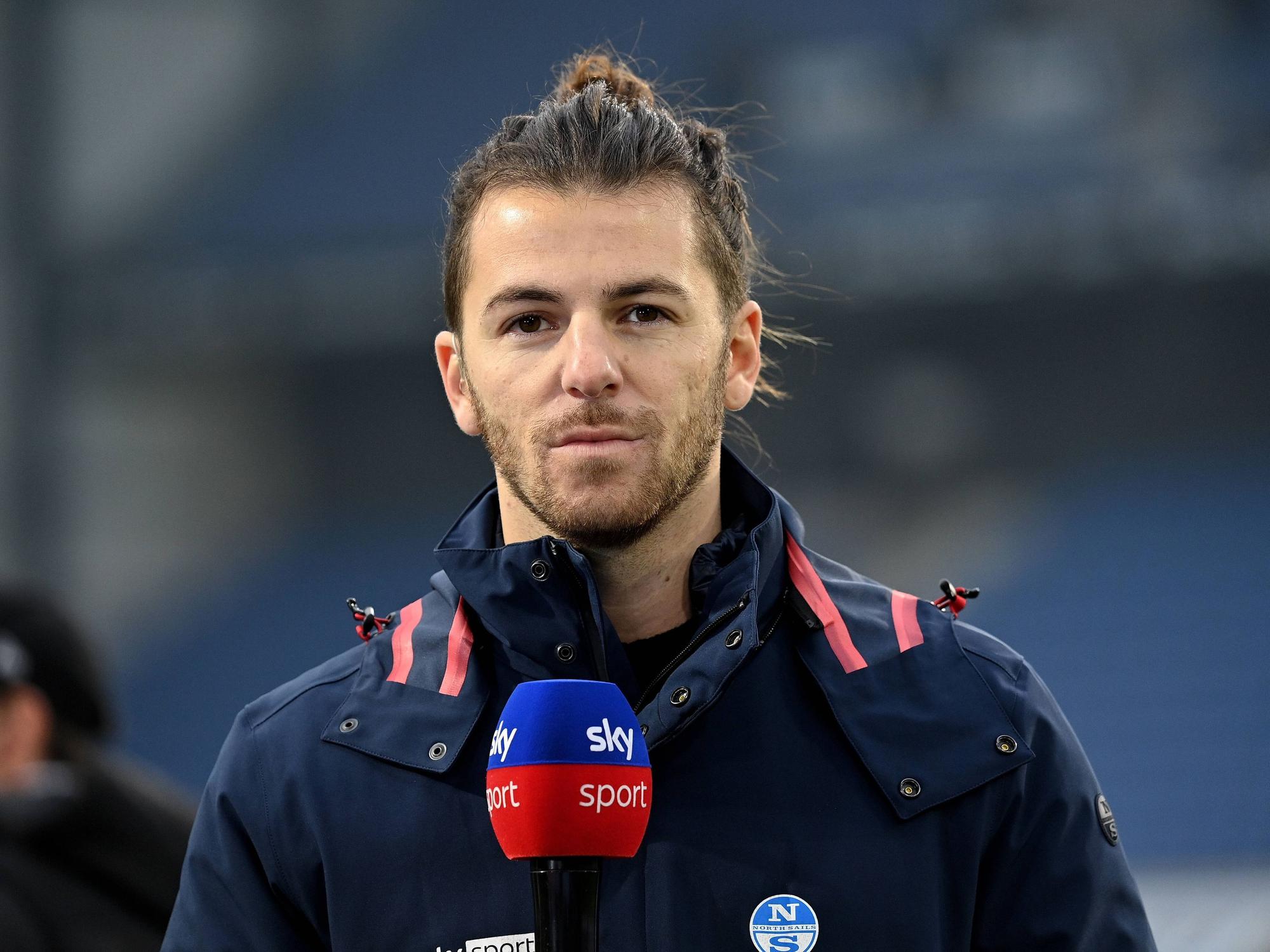 Riccardo Basile steht mit einem Sky-Mikro am Spielfeldrand.