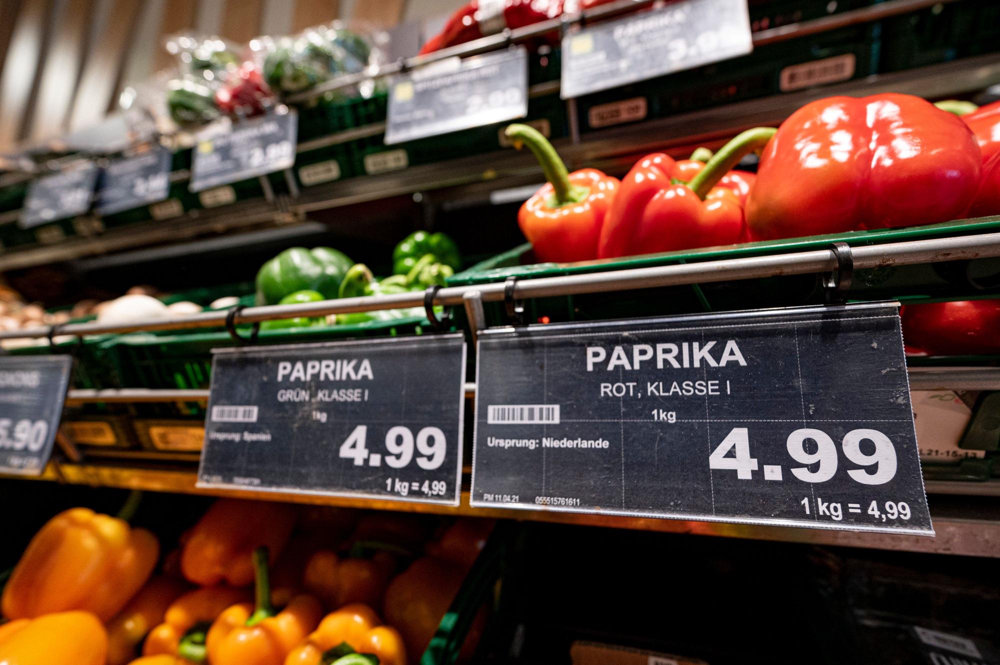 Ein Preisschild von Paprikas hängt an der Obsttheke in einem Supermarkt