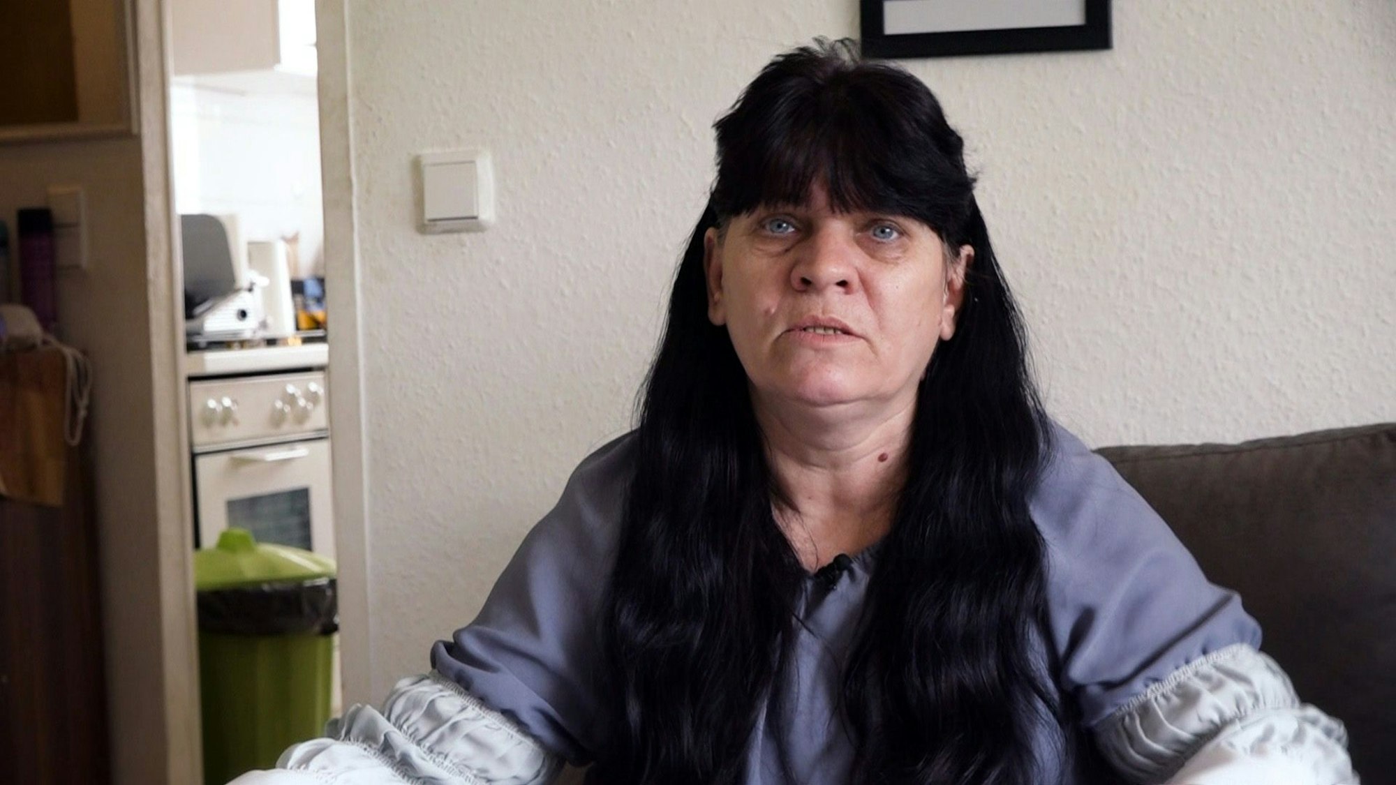 Das Foto zeigt die „Hartz und herzlich“-Darstellerin aus Mannheim in ihrer Wohnung, wo sie auf einer Couch sitzt.