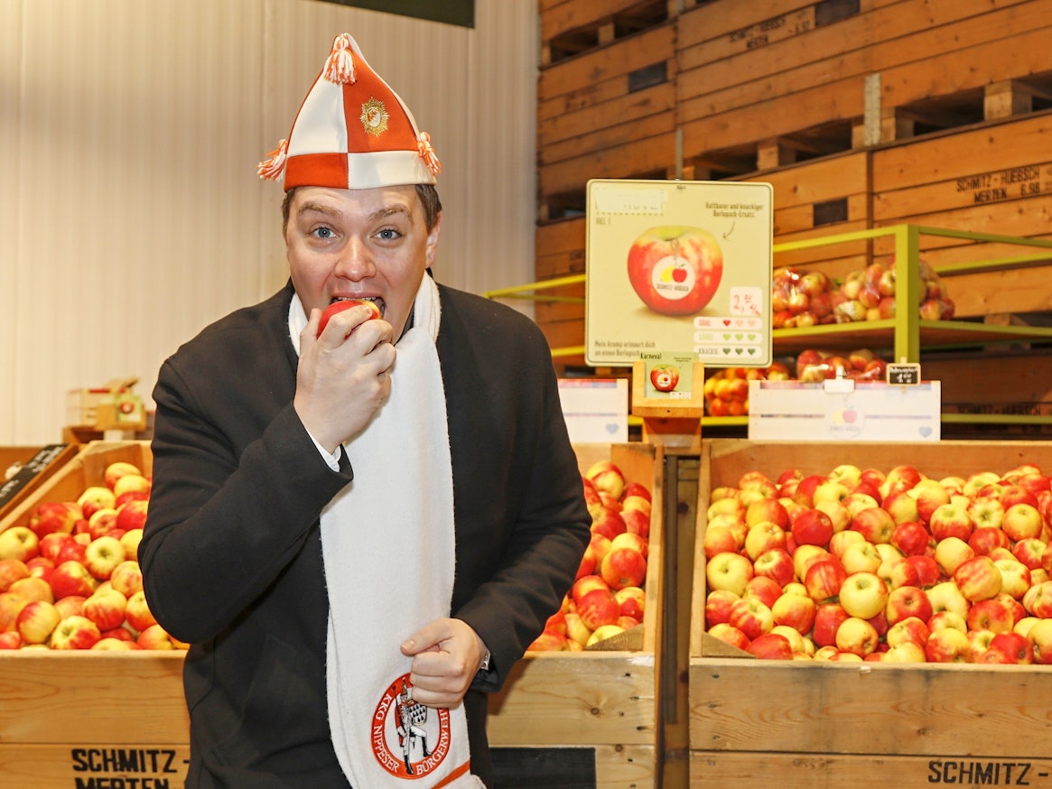 Michael Gerhold, Präsident der Nippeser Bürgerwehr, probiert in Bornheim am 17. Januar den Apfel "Karneval".