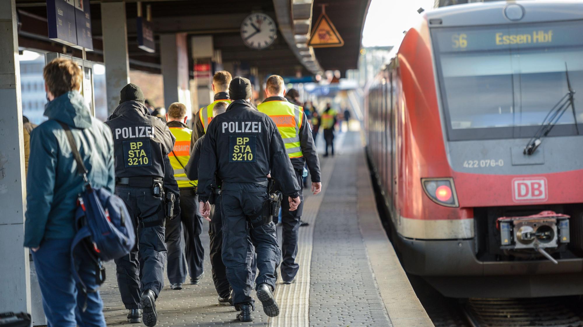 Einsatzkräfte der Bundespolizei laufen am Bahnhof Köln Messe/Deutz auf einem Bahnsteig, an dem eine Bahn hält, entlang.