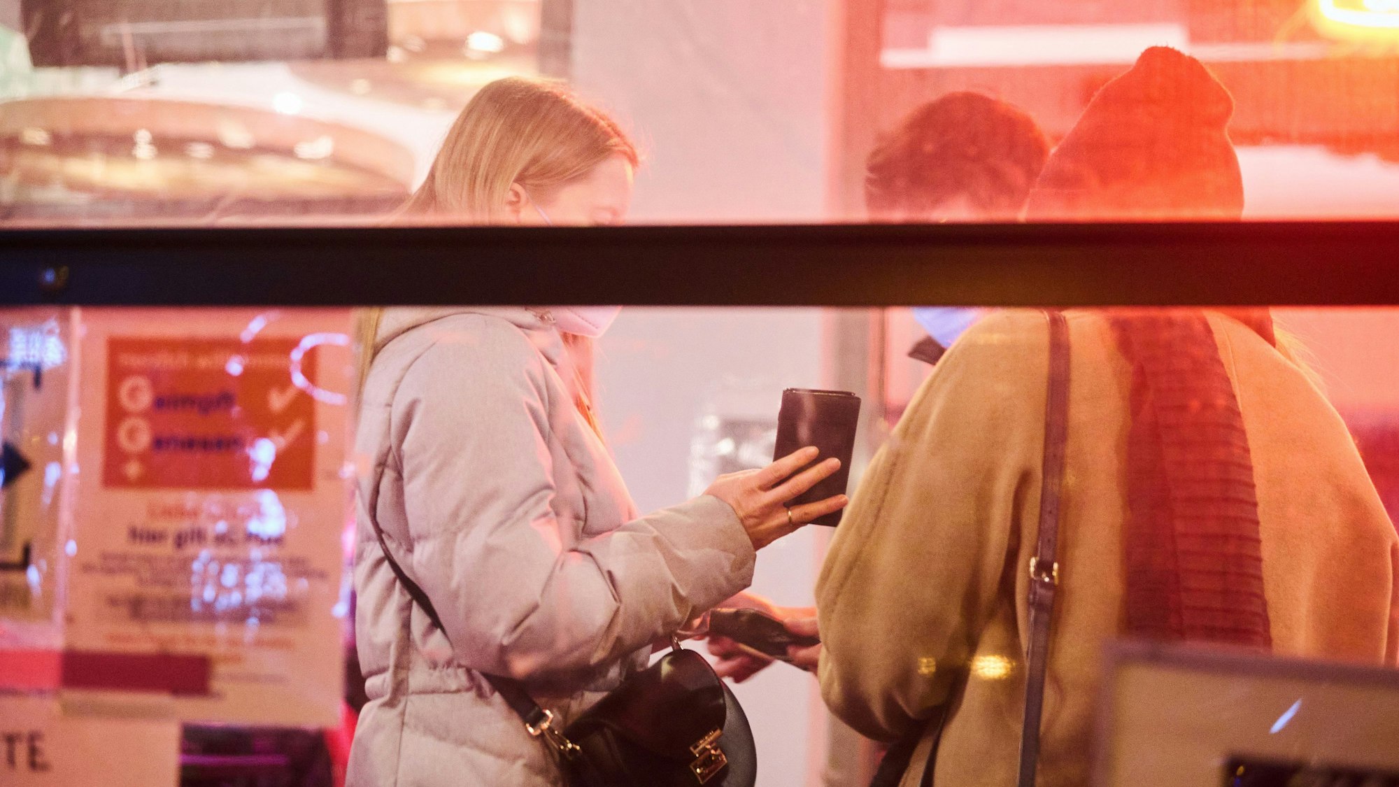 Eine Mitarbeiterin eines Restaurants kontrolliert den Impfstatus zweier Personen in Berlin.