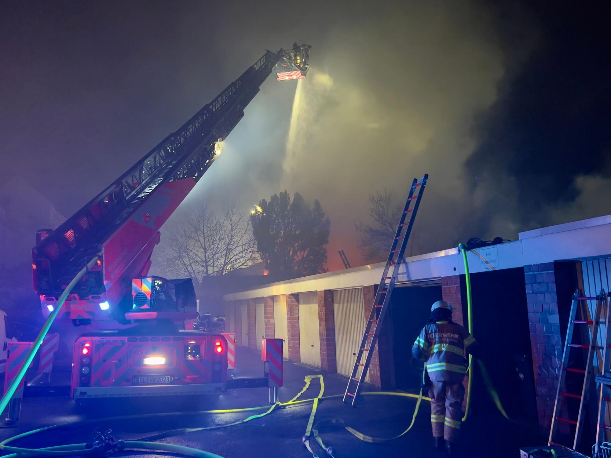 Einsatzkräfte der Feuerwehr vor der brennenden Lagerhalle