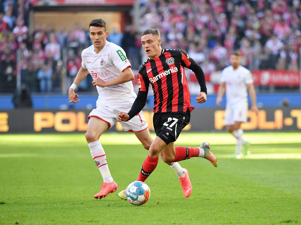 Florian Wirtz führt den Ball, Köln Dejan Ljubicic jagt ihm hinterher.