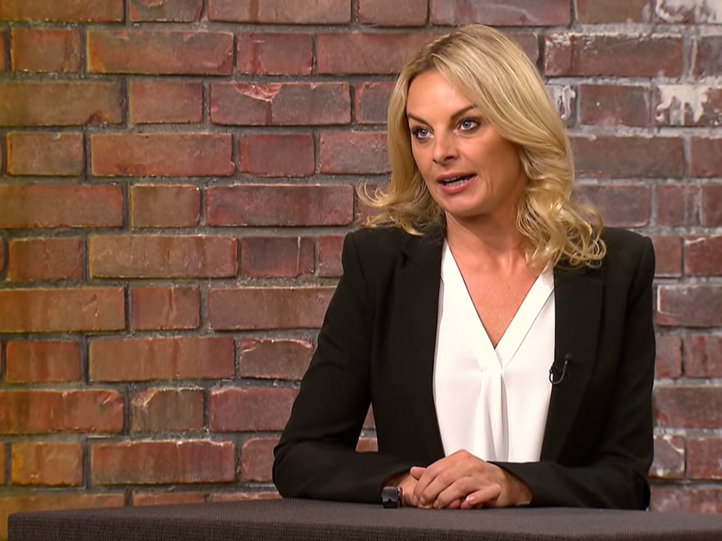 Händlerin Susanne Steiger sitzt an einem Tisch in der ZDF-Show „Bares für Rares“.
