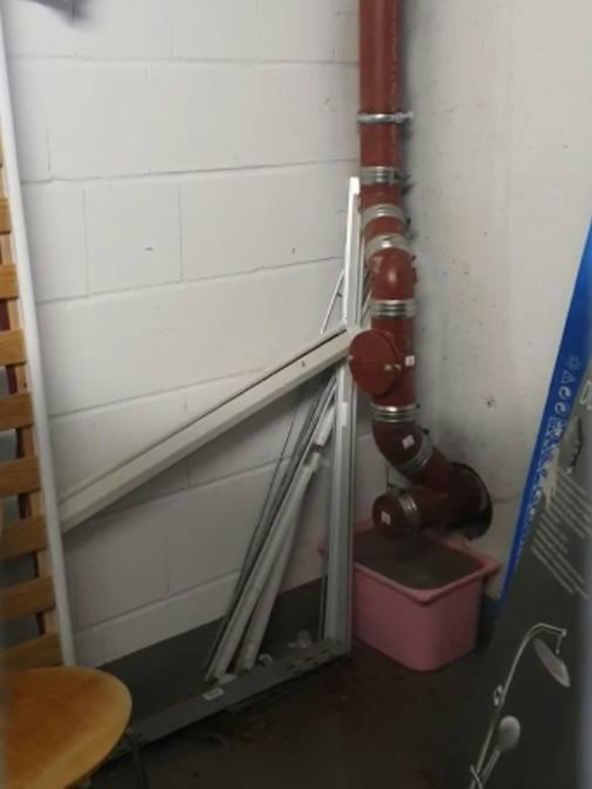 Ein Eimer steht unter einem undichten Rohr.