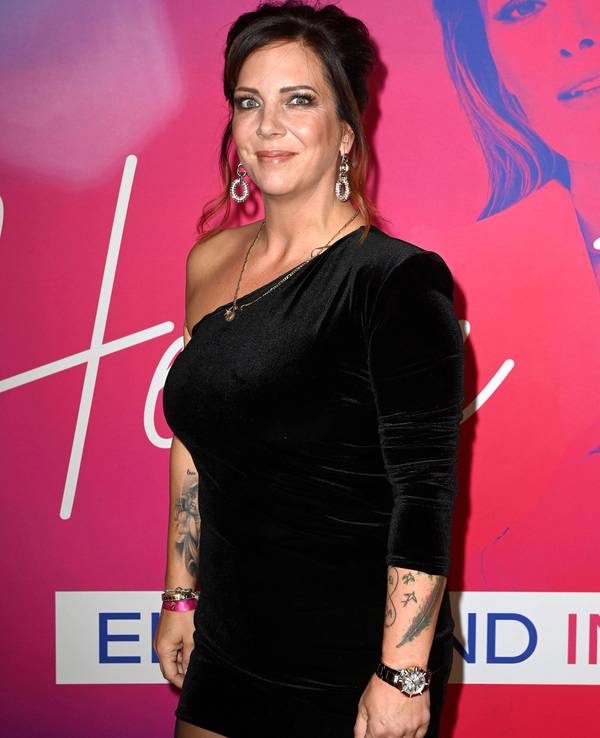 Das Foto zeigt Daniela Büchner bei der Premiere der Sat.1 TV-Show "Helene Fischer - Ein Abend im Rausch" im Delphi-Filmpalast vor einer roten Wand mit dem Gesicht von Helene Fischer.