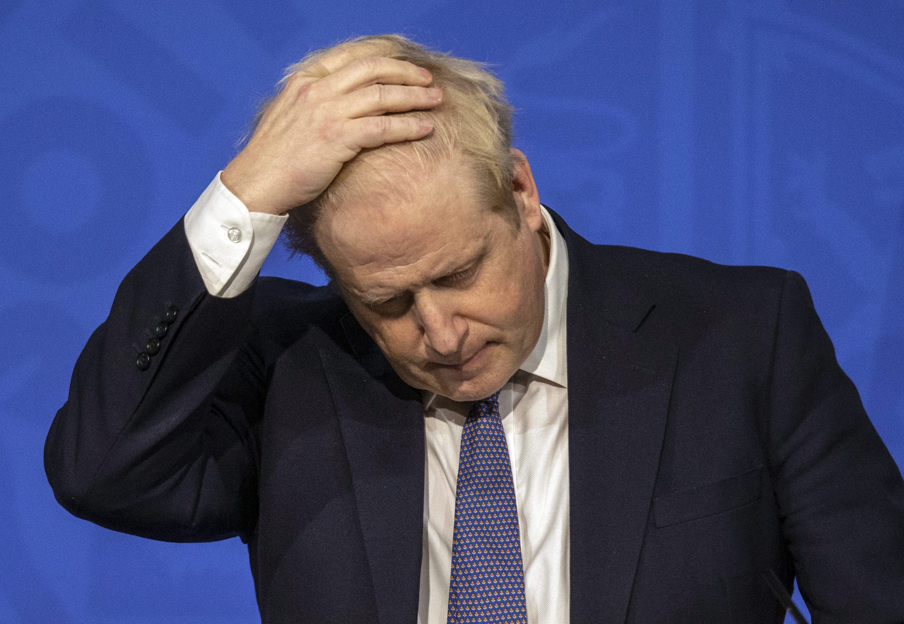 ARCHIV - 04.01.2022, Großbritannien, London: Boris Johnson, Premierminister von Großbritannien, fasst sich während einer Pressekonferenz mit der Hand an den Kopf. Foto vom 4. Januar 2022.
