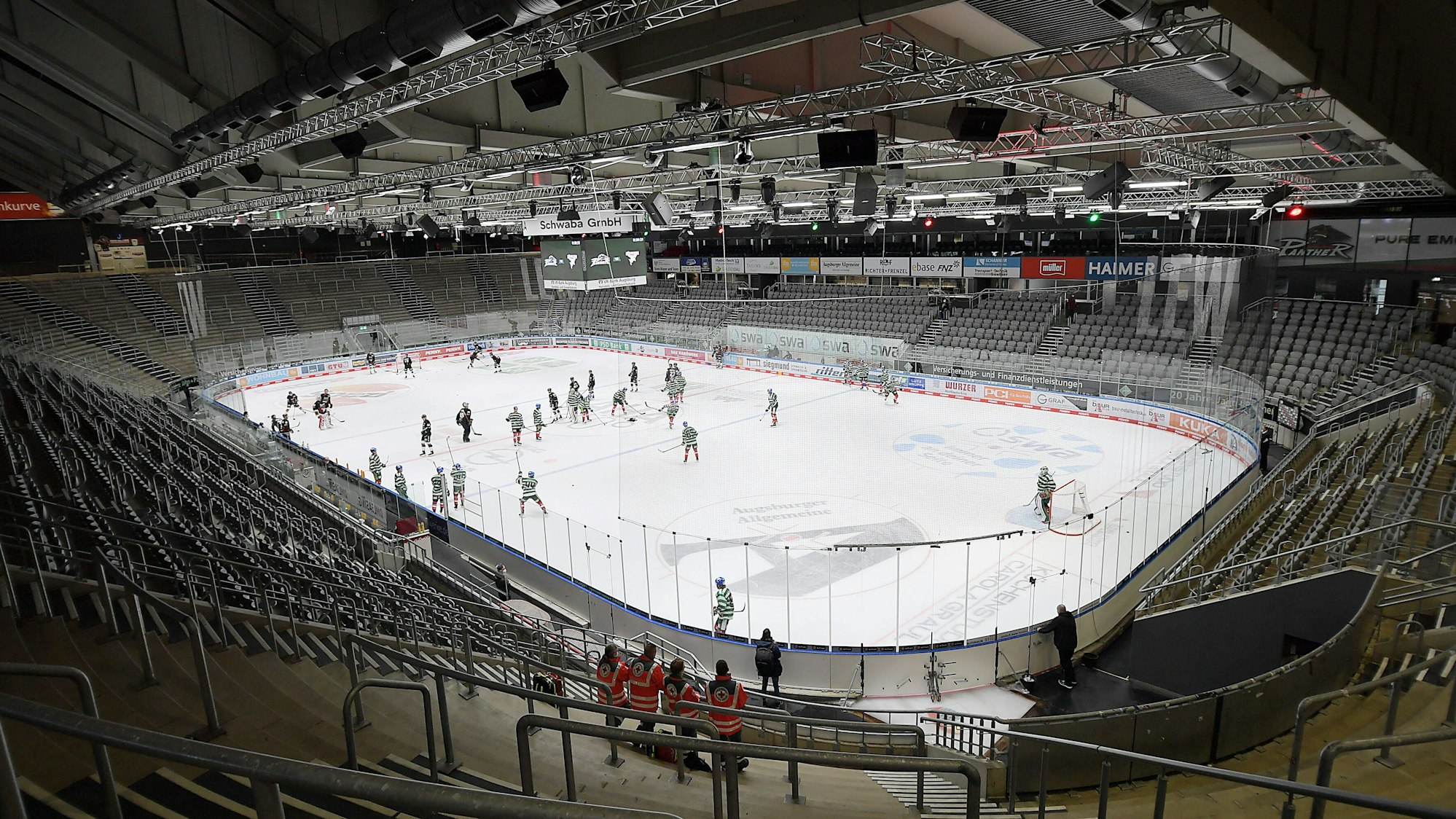 Die Mannschaften stehen auf dem Feld, die Tribünen sind leer.