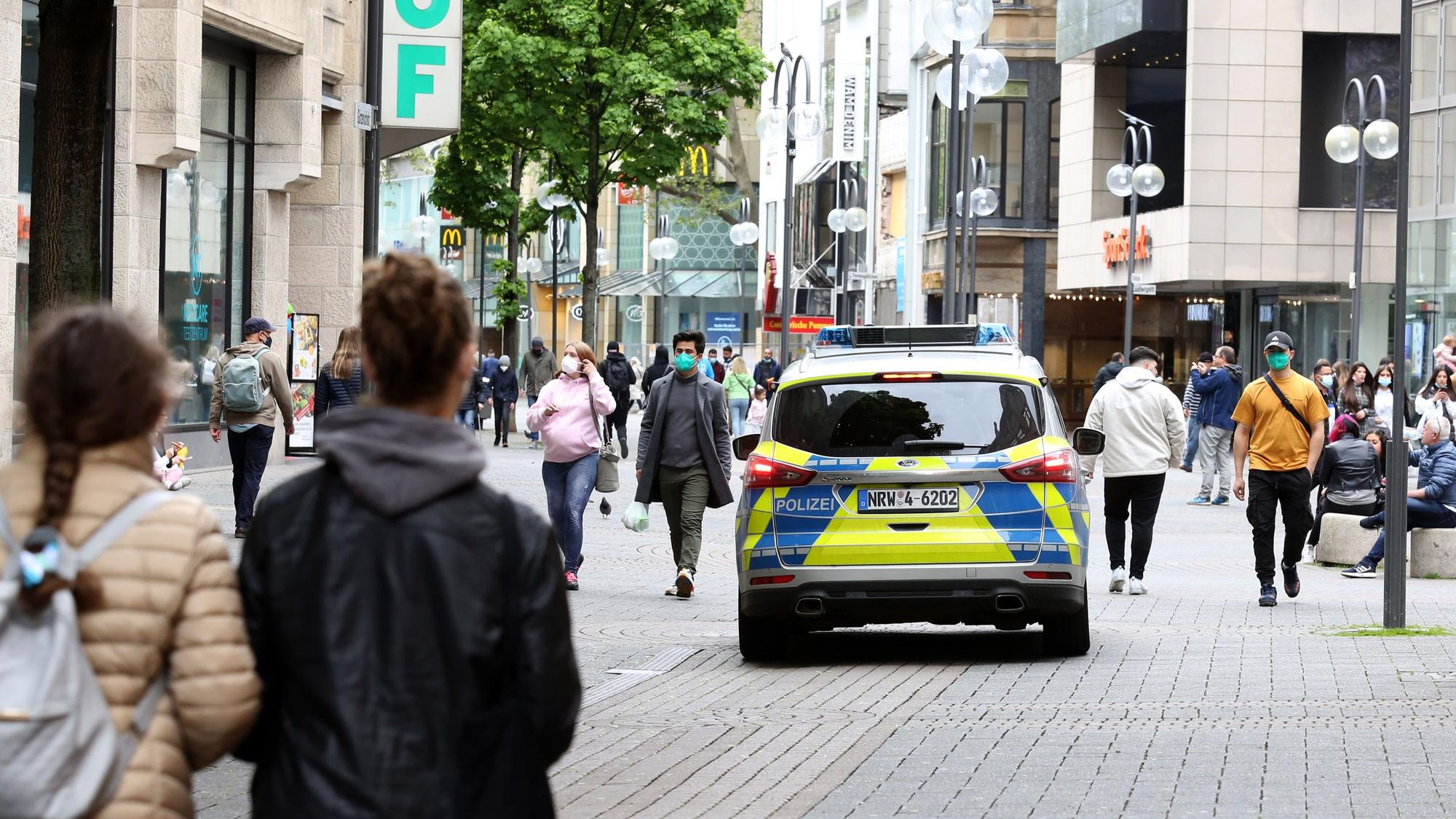 Ein Streifenwagen fährt über die Schildergasse, wo zahlreiche Personen unterwegs sind.