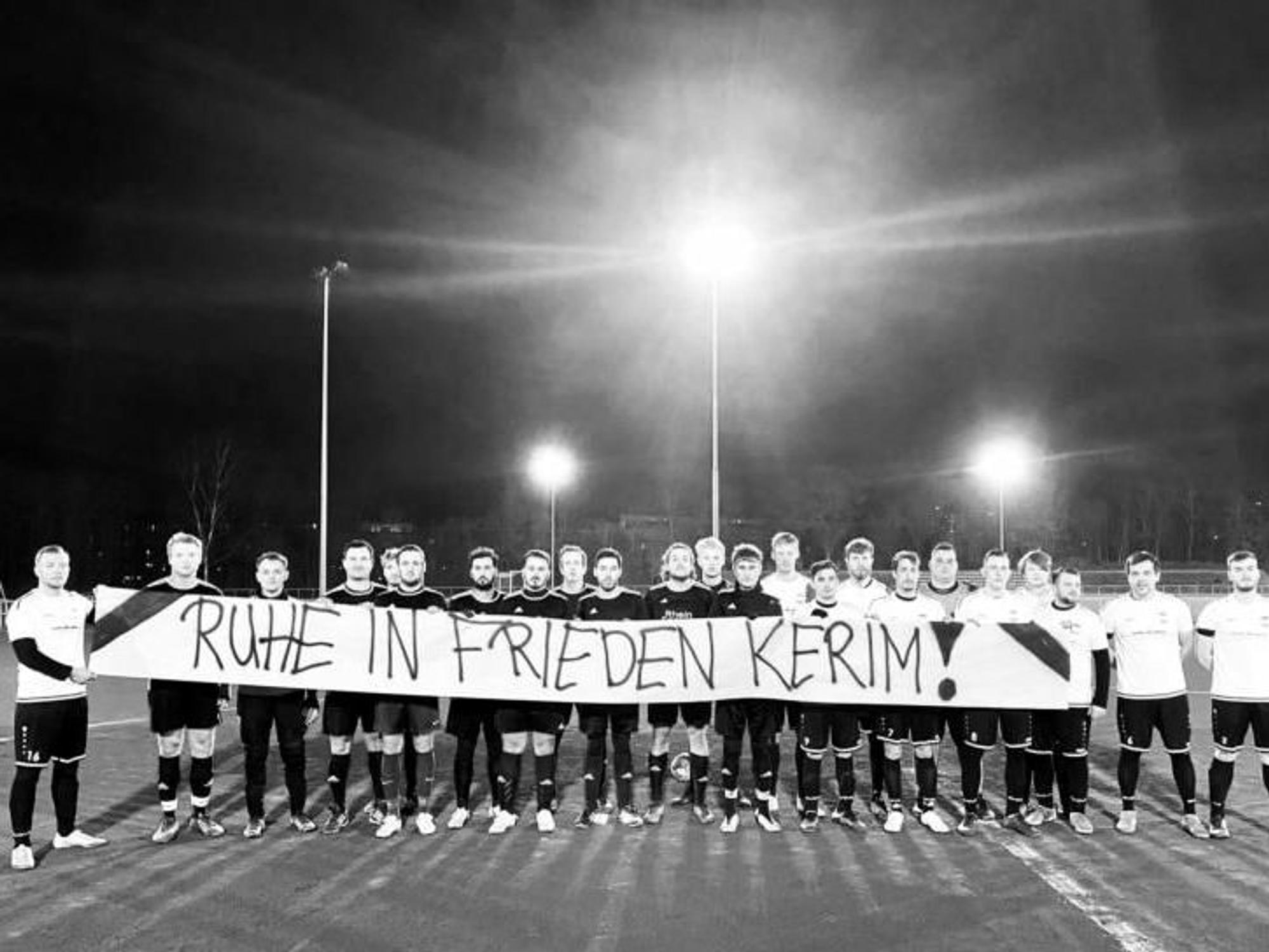 Fußballspieler halten ein Banner.