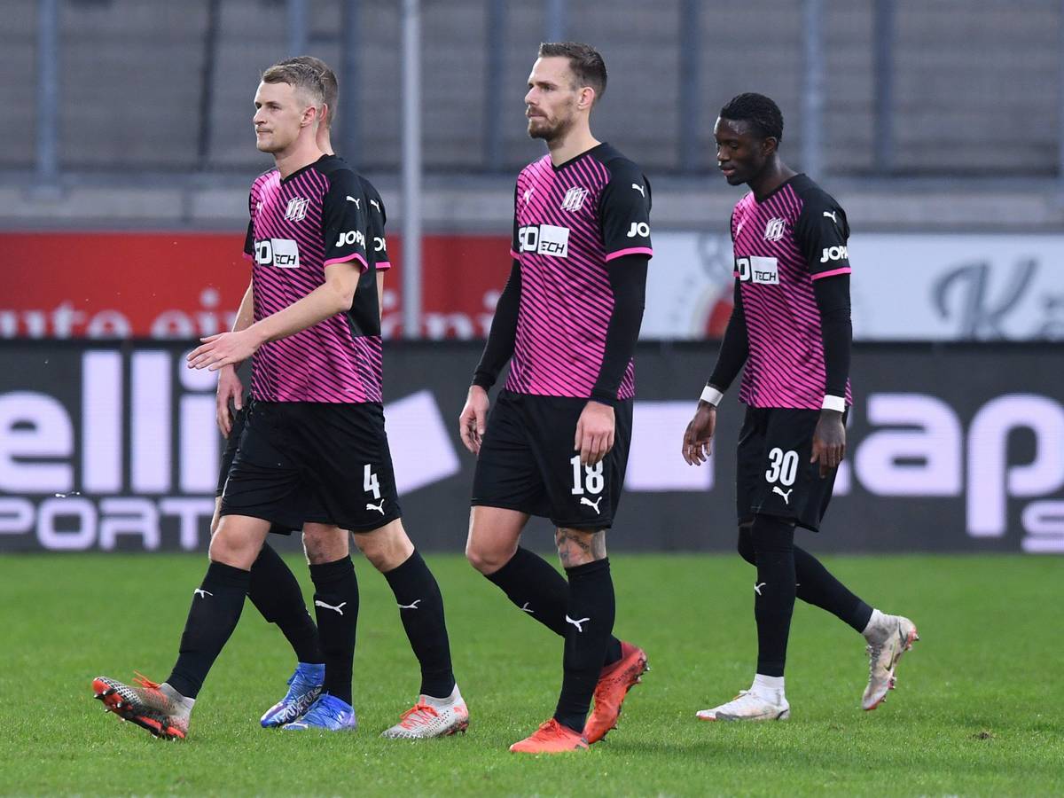 Osnabrücks Aaron Opoku (r) verlässt nach rassistischen Beleidigungen von den Zuschauerrängen mit Teamkollegen das Stadion.