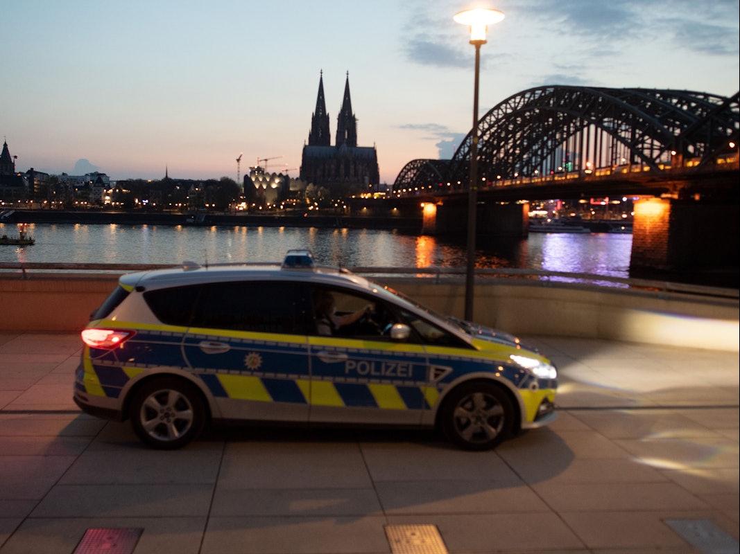 Ein Polizeiauto fährt am Rheinufer Streife. Foto von der dpa