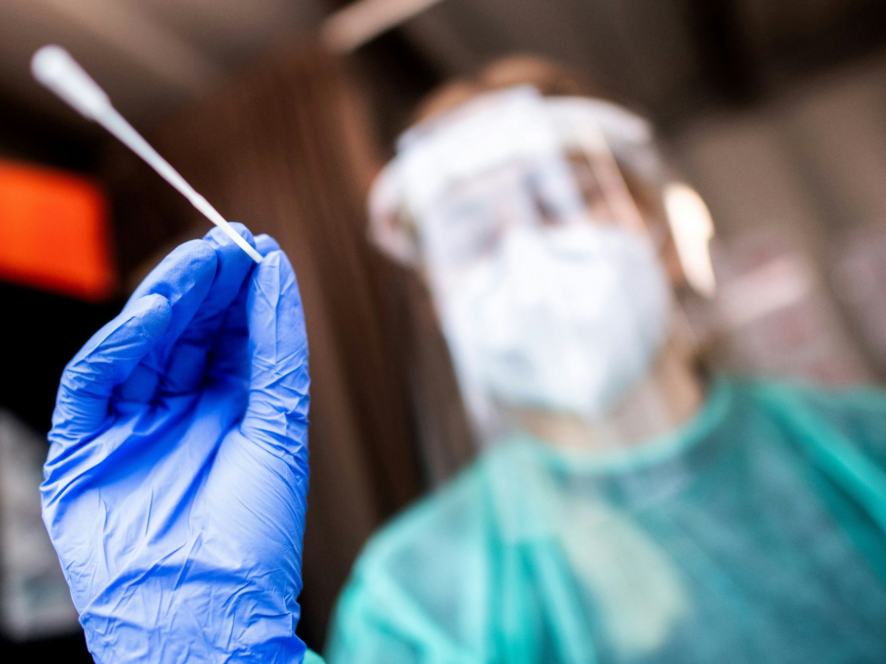 Eine Mitarbeiterin einer Teststation in der Oldenburger Innenstadt nimmt einen Abstrich.