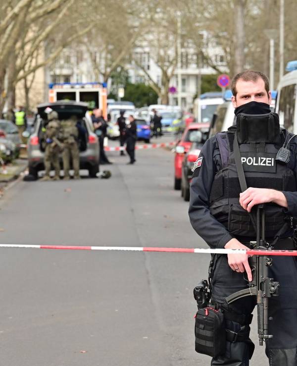 Einsatzkräfte stehen vor der Schule, die Straße ist abgesperrt.