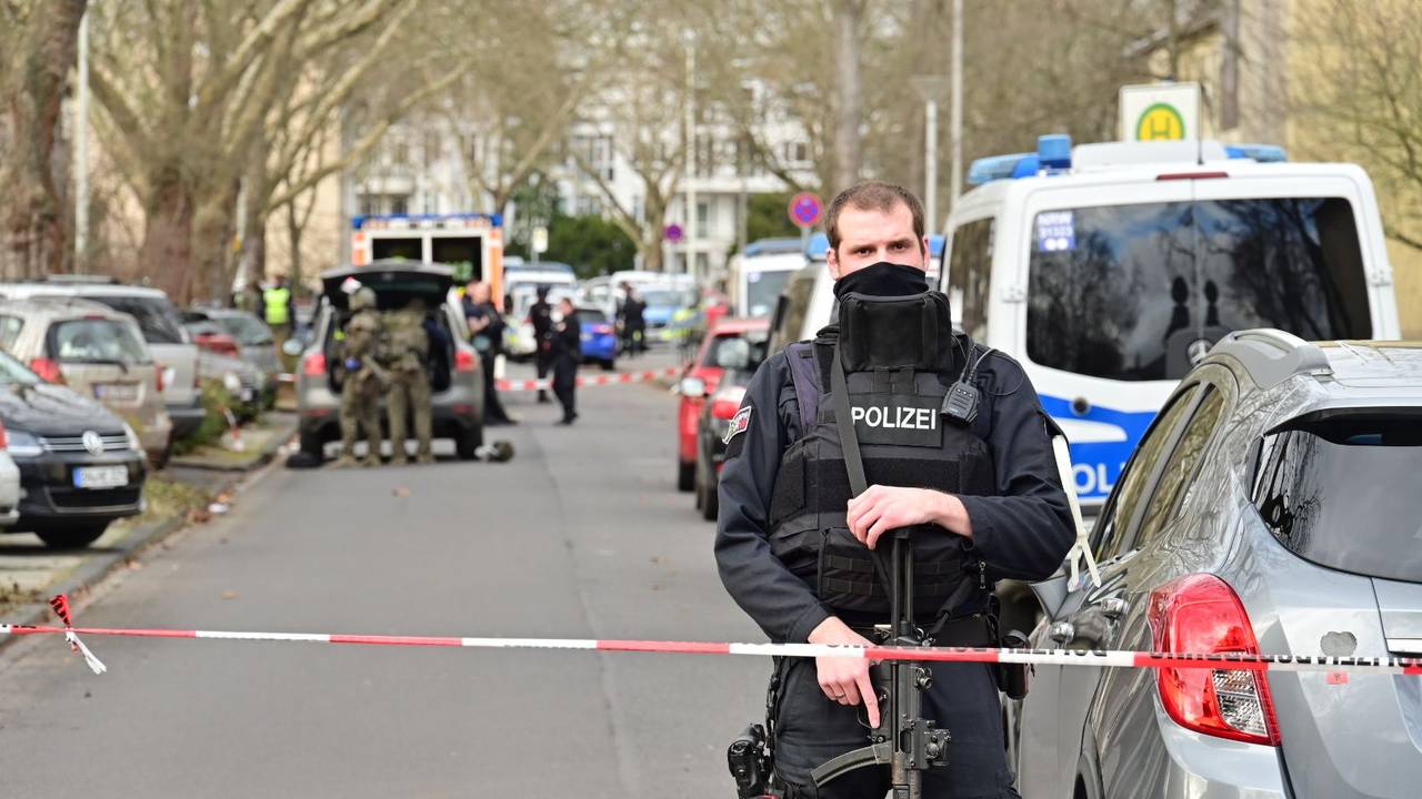 Einsatzkräfte stehen vor der Schule, die Straße ist abgesperrt.