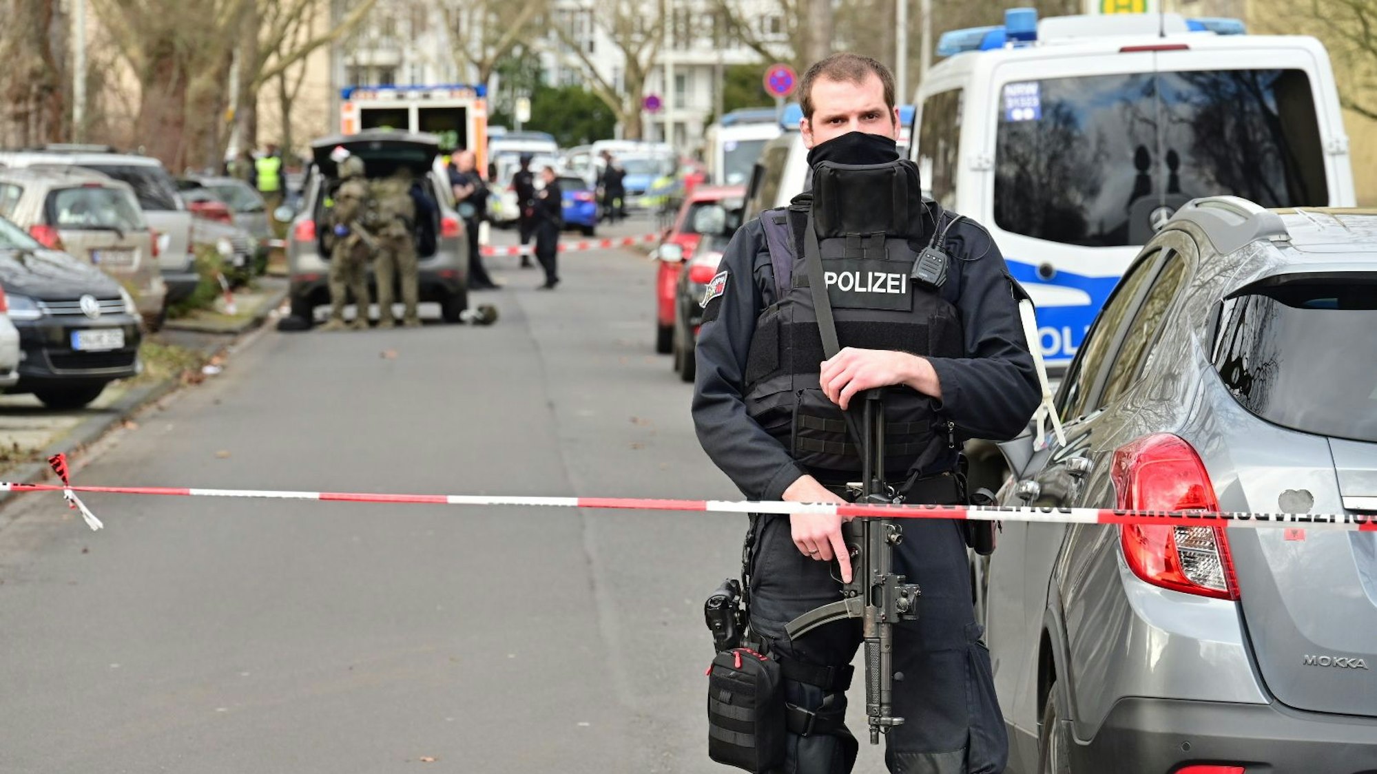 Einsatzkräfte stehen vor der Schule, die Straße ist abgesperrt.