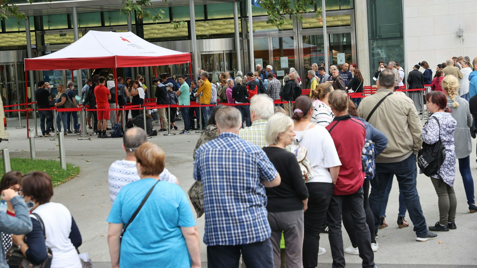 Menschen stehen vor dem Kongresshaus von Salzburg, um eine Impfung gegen das Coronavirus zu erhalten