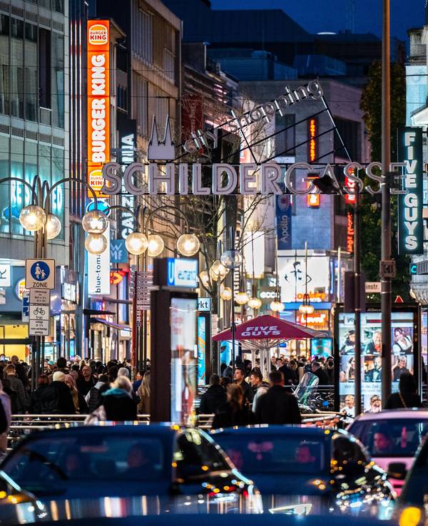 Die Kölner Schildergasse mit heller Beleuchtung im Abendlicht.