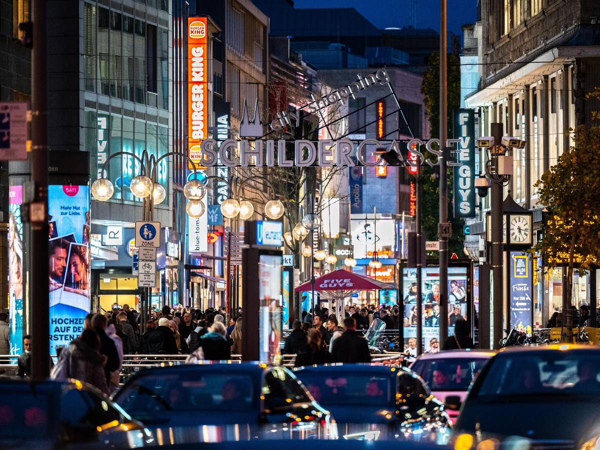 Die Kölner Schildergasse mit heller Beleuchtung im Abendlicht.