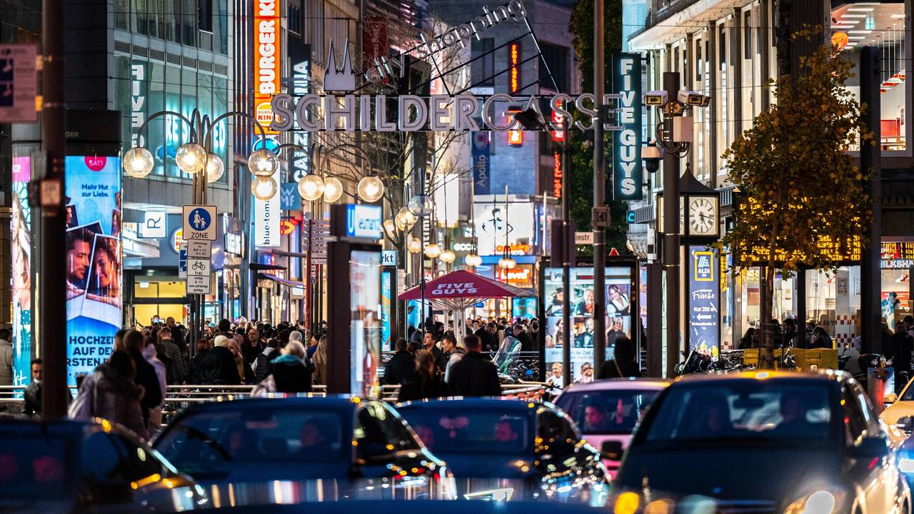 Die Kölner Schildergasse mit heller Beleuchtung im Abendlicht.