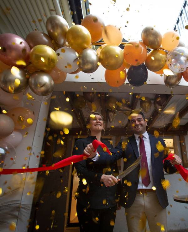 Julia Komp und Yunus Özananar durchschneiden ein rotes Band, drumherum sind viele Luftballons