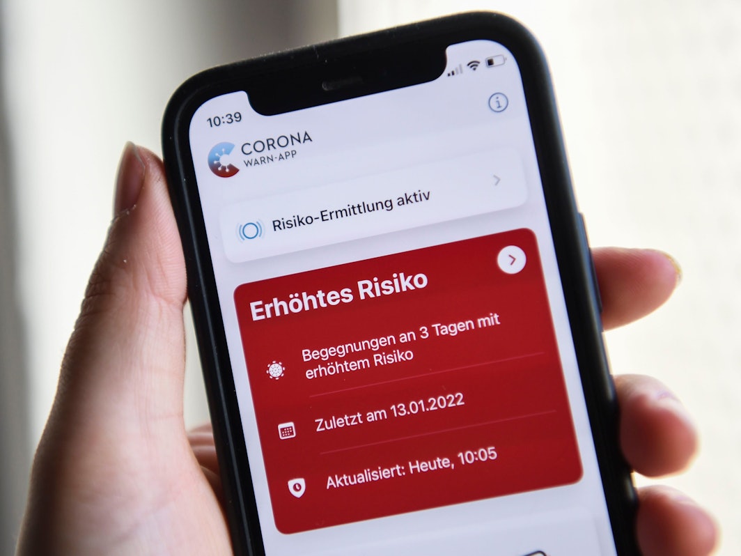 Berlin: Auf einem Smartphone zeigt die geöffnete Corona-Warn-App ein erhöhtes Risiko an. Die rote Anzeige warnt vor drei Begegnungen mit Corona-positiv getesteten Personen.