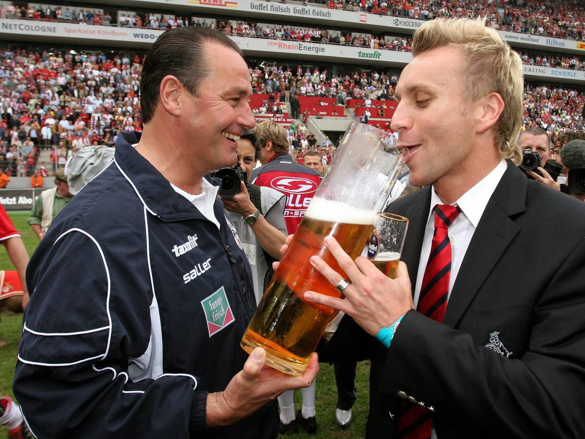 Trainer Huub Stevens (li.) verleitet Sebastian Schindzielorz (beide Köln) während der Aufstiegsfeier zum Bier trinken.