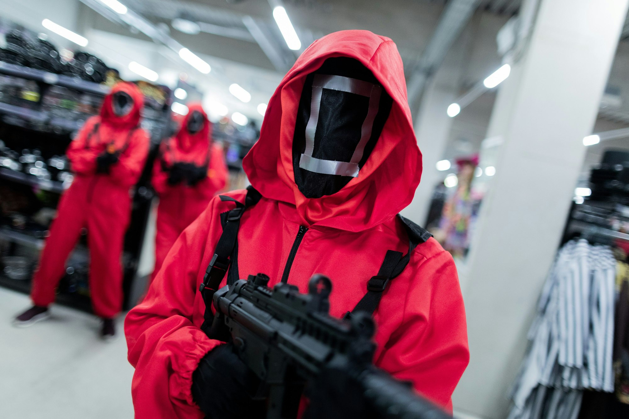 Mitarbeiter des Kostümhändlers Deiters posieren in Kostümen aus der Serie "Squid Game" des Streaming-Anbieters Netflix.