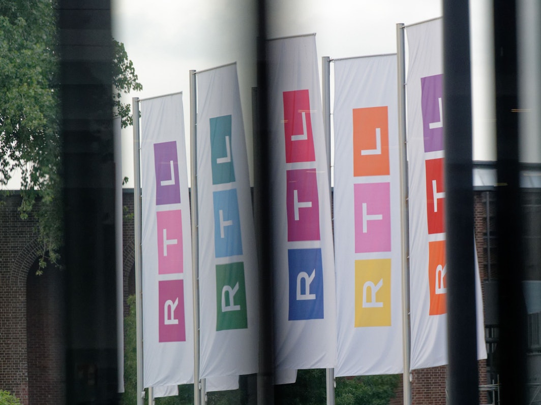 Fahnen des Fernsehsenders RTL stehen auf dem Platz vor dem Firmengebäude.