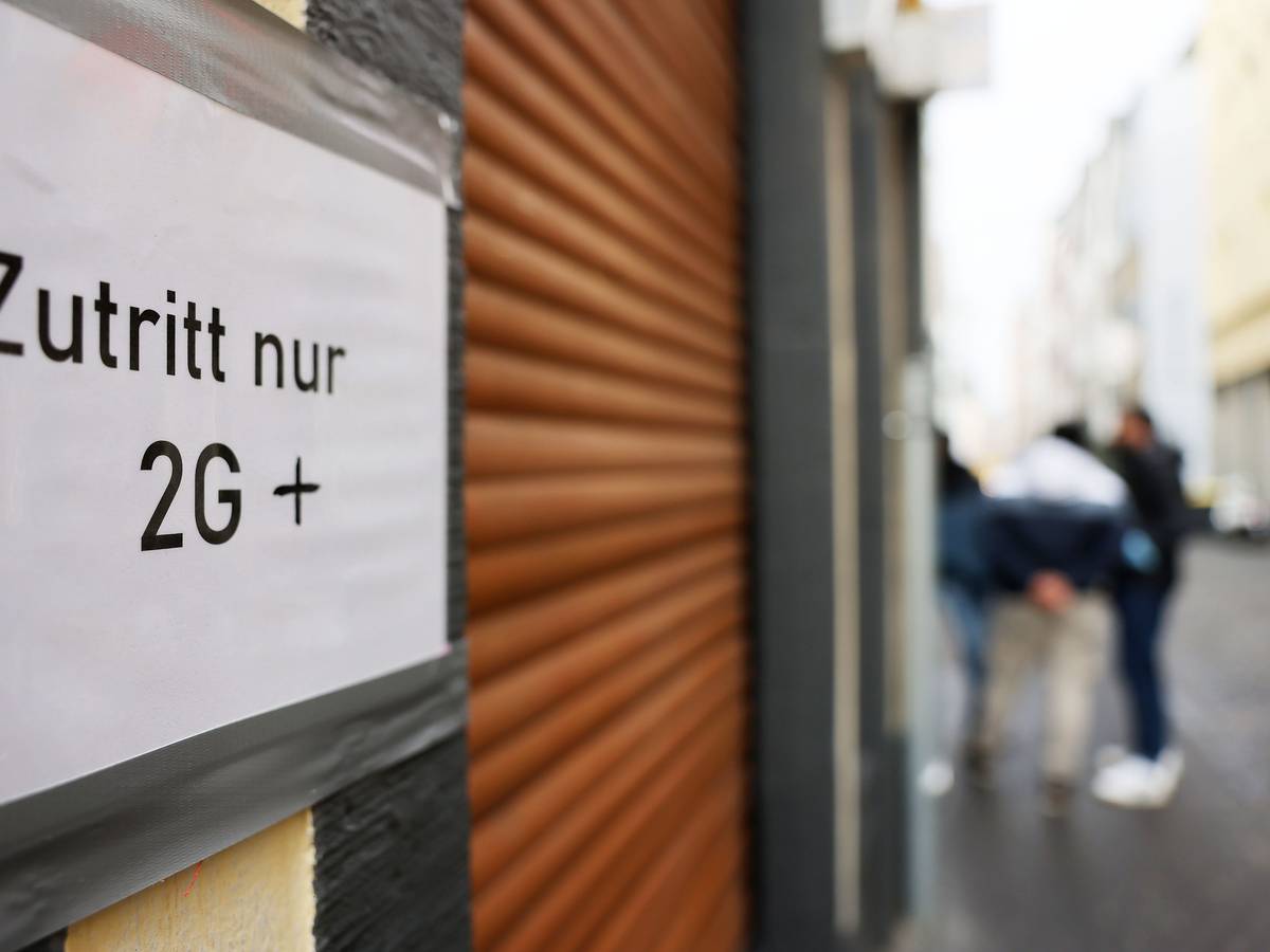 Ein Schild am Eingang einer Gaststätte mit geschlossenen Rollläden weist am 21. Januar 2022 auf die 2G-plus-Regel in Köln hin. Die Pandemie bestimmt weiterhin den Alltag.