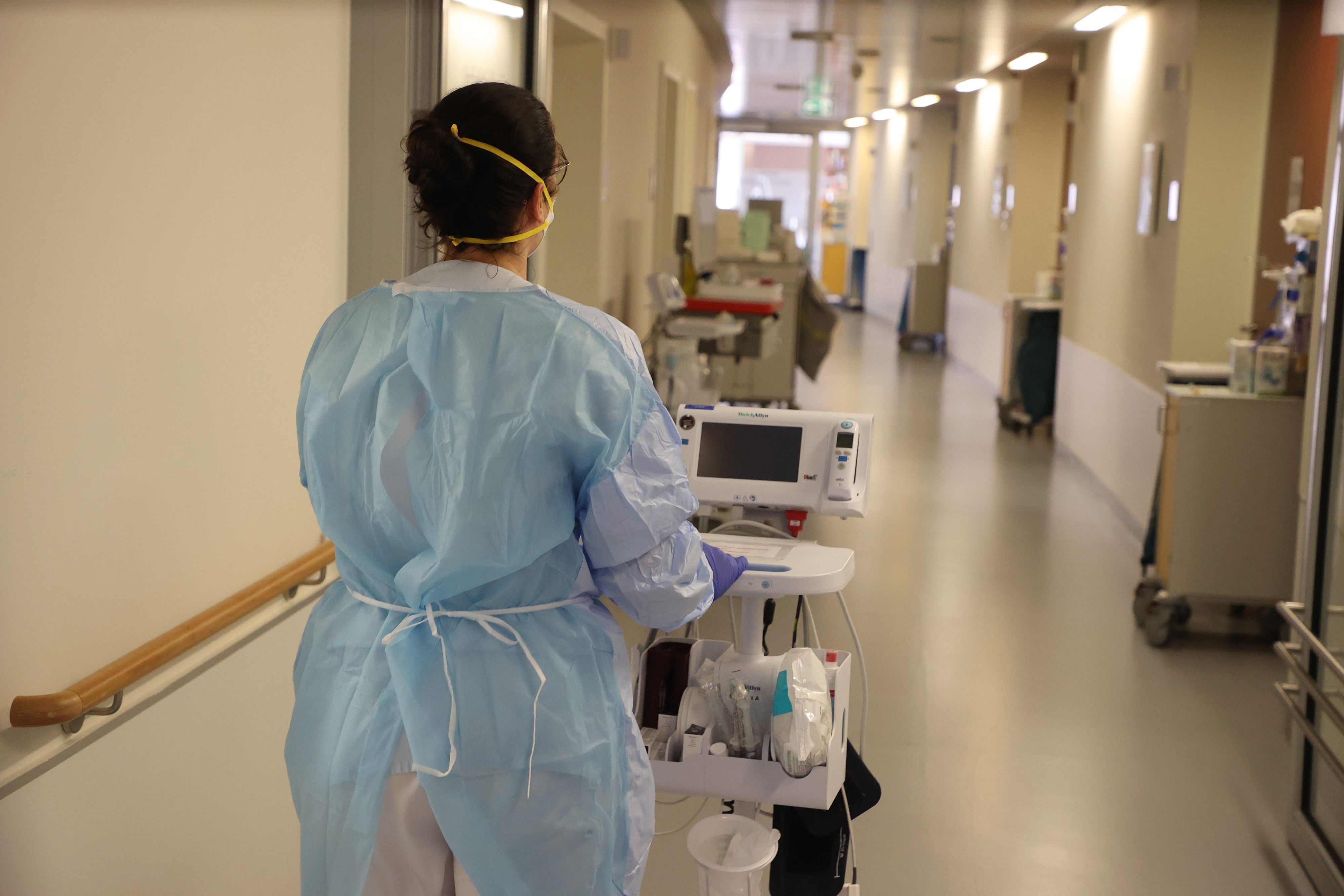 Eine Krankenschwester läuft mit medizinischem Gerät auf dem Flur der Corona-Station im Krankenhaus entlang. Das Bild wurde am 13. Januar 2022 aufgenommen.