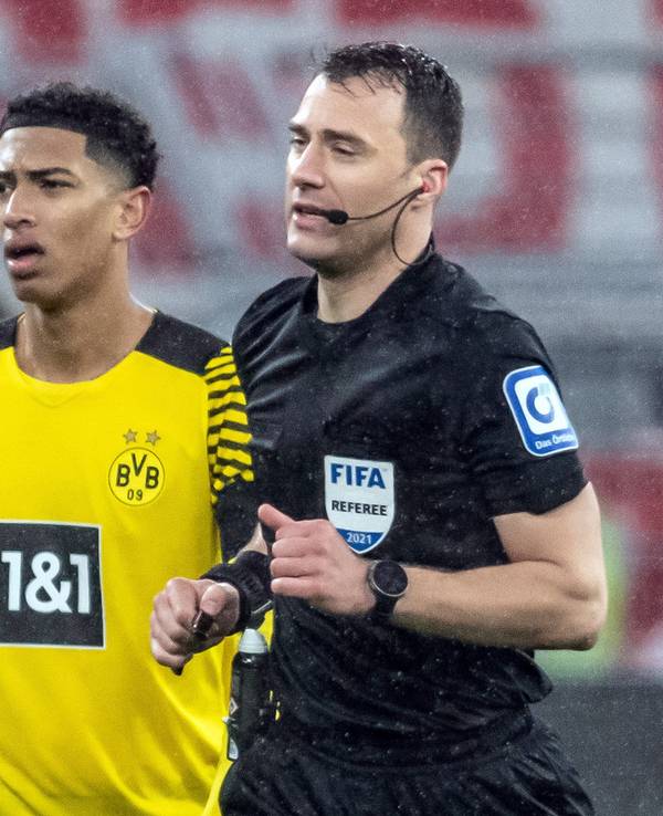 Schiedsrichter Felix Zwayer (r) läuft an Dortmunds Jude Bellingham zum Spielfeldrand, um sich den Videobeweis für den anschließend gegebenen Strafstoß anzuschauen.