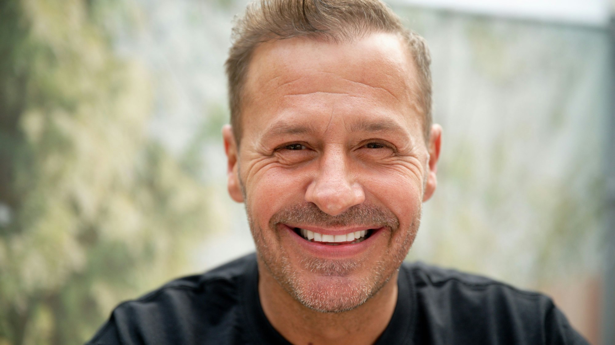 Schauspieler und Reality-Star Willi Herren schaut bei der Eröffnung von „Willi Herren’s Rievkooche Bud“ in die Kamera.