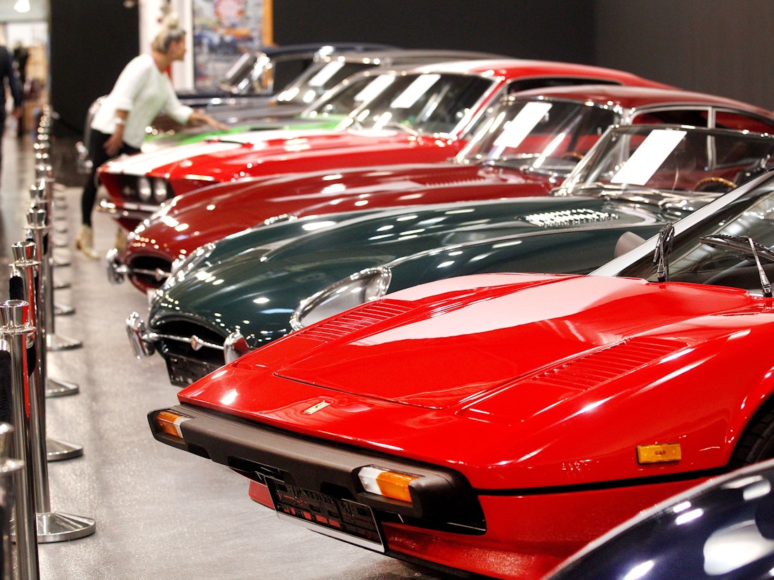 Eine Fachbesucherin schaut sich edel restaurierte Oldtimer auf der Tuningmesse "Essen Motor Show" an.