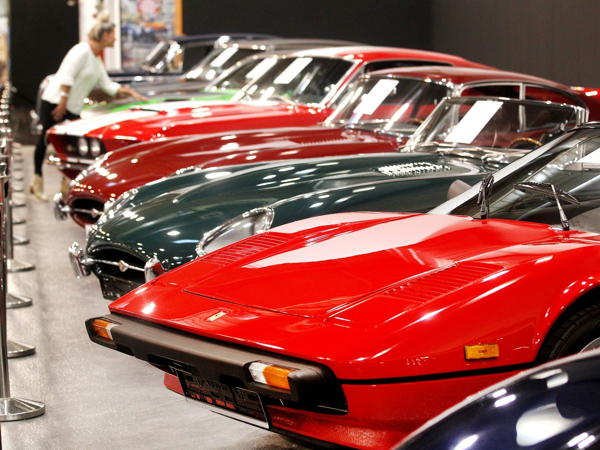 Eine Fachbesucherin schaut sich edel restaurierte Oldtimer auf der Tuningmesse "Essen Motor Show" an.
