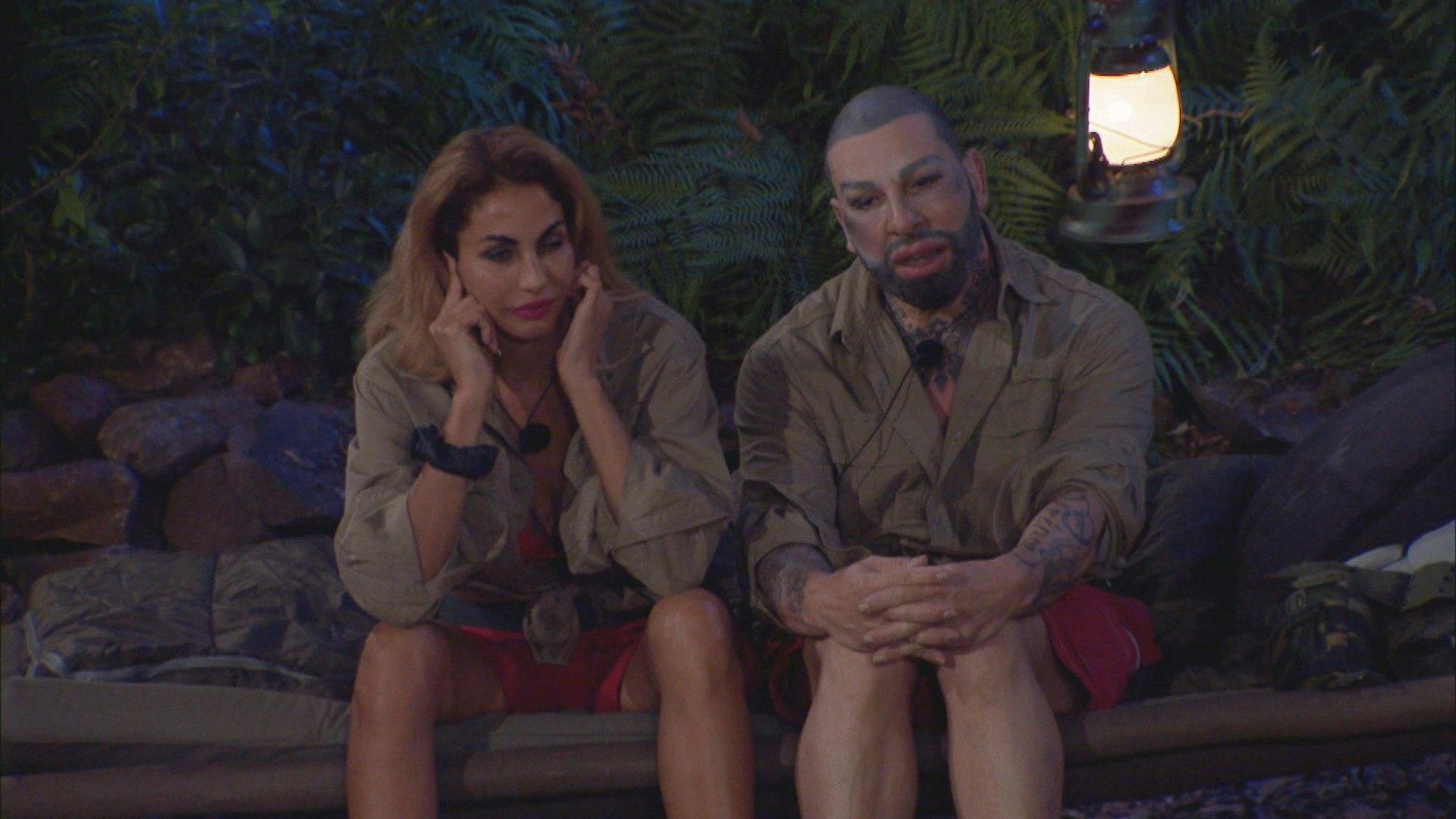 Janina Youssefian hälts sich die Ohren zu. Harald Glööckler sitzt mit ihr gemeinsam im Dschungelcamp.