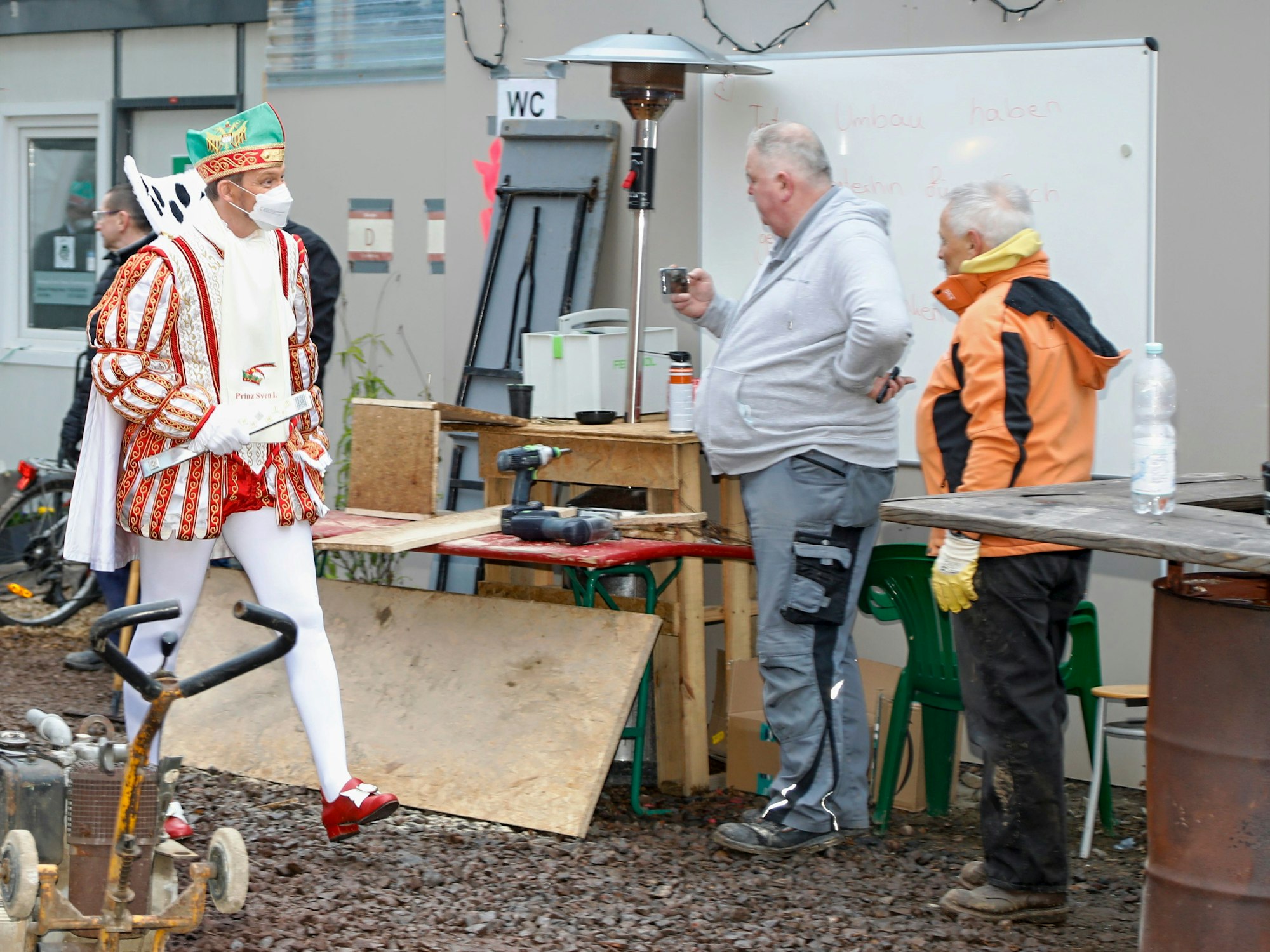Prinz Sven unterhält sich mit zwei Arbeitern.