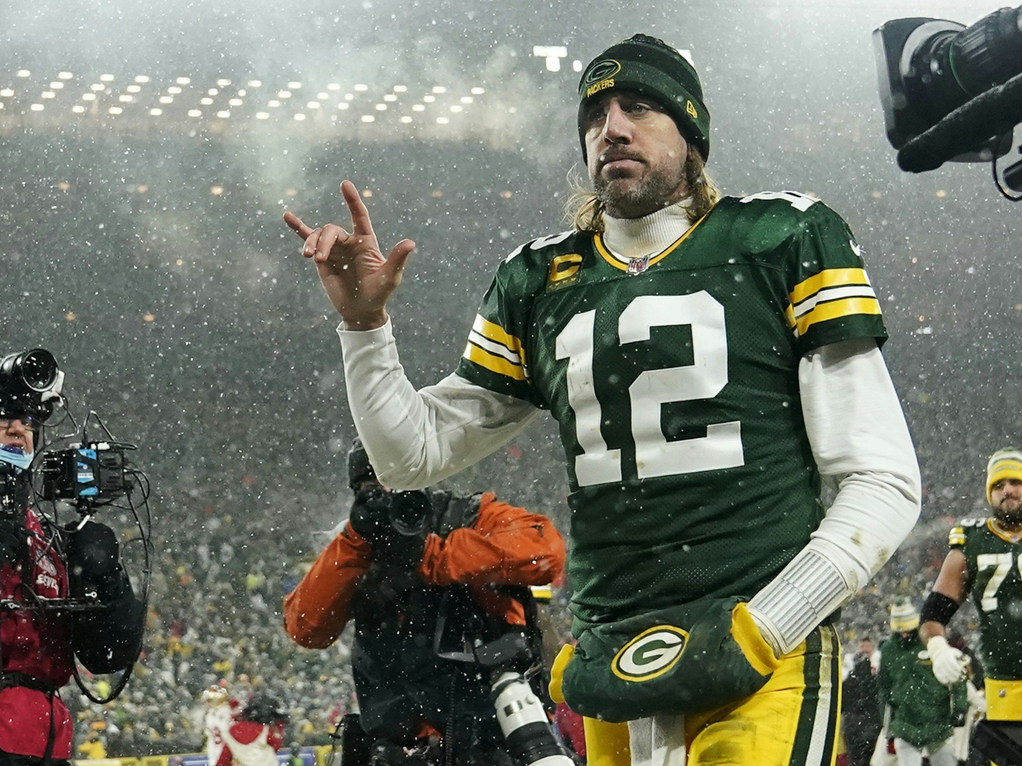 Aaron Rodgers zeigt mit der rechten Hand einen Rocker-Gruß: Er hebt den kleinen Finger und den Zeigefinger, dabei spreizt er den Daumen ab.
