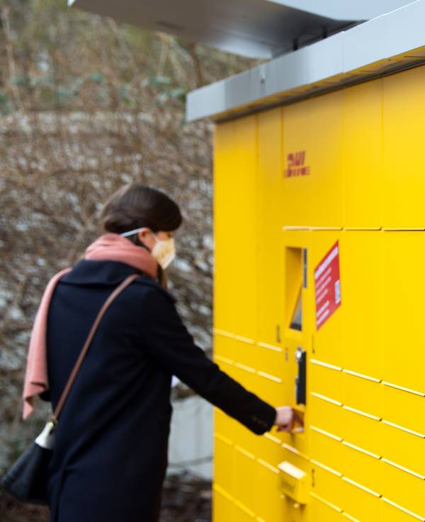 Eine Post-Mitarbeiterin bedient eine neue Poststation. Das Bild entstand am 16. Februar 2021.
