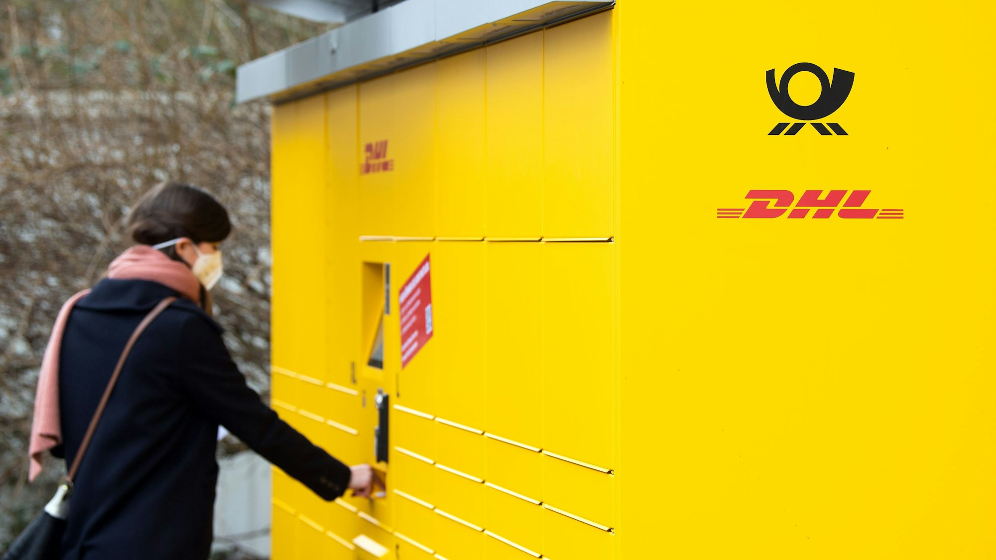 Eine Post-Mitarbeiterin bedient eine neue Poststation. Das Bild entstand am 16. Februar 2021.